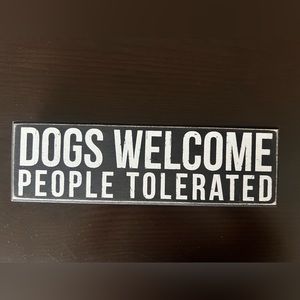 Dogs welcome people tolerated sign.